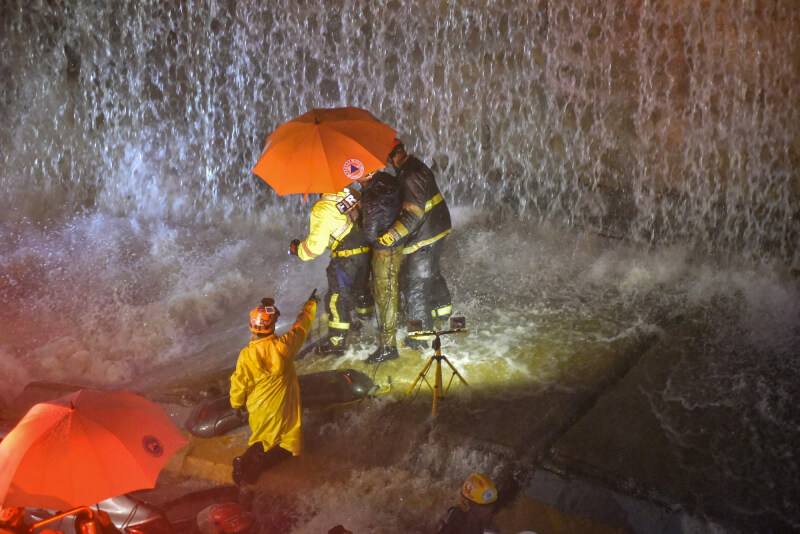 多明尼加18日暴雨成災，造成牆面倒塌，救難人員尋找被困在牆下的人。（法新社）