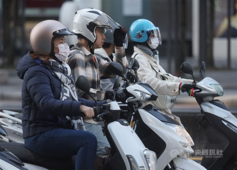 圖為台北市信義區機車騎士穿著保暖衣物騎車。（中央社檔案照片）