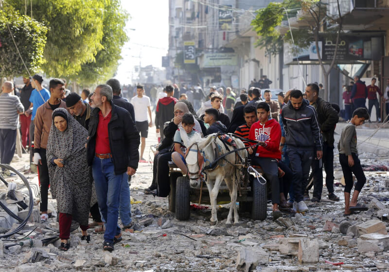加薩走廊一處難民營遭襲擊，建築物嚴重受損，巴勒斯坦人21日相繼出走。（安納杜魯新聞社）