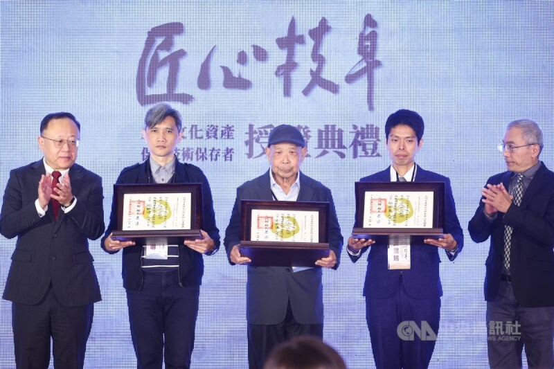 文化部24日在國立台灣博物館舉行112年重要文化資產保存技術保存者授證典禮,文化部長史哲(左)頒發證書給「土水修造技術」保存者李清海(中)與蘇清良及「剪黏泥塑技術」保存者徐明河,因蘇清良與徐明河已辭世,由蘇清良孫子蘇建銘(右2)及徐明河兒子徐朝琳(左2)代為接受證書。中央社記者王騰毅攝 112年11月24日