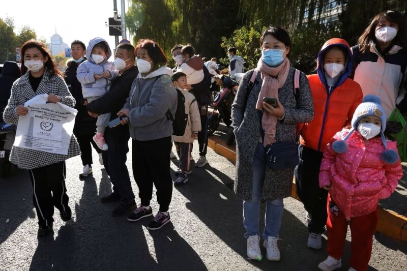 圖為24日北京民眾在兒童醫院就診後等待乘車。（路透社）
