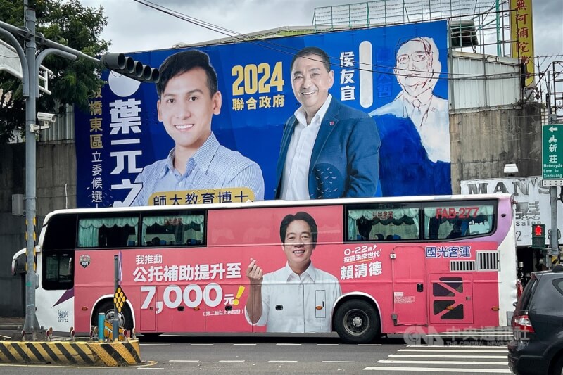 國民黨立委參選人葉元之25日請來電影看板繪畫師，以手繪趙少康方式遮蓋柯文哲照片，一輛有賴清德競選廣告的公車恰巧經過。中央社記者王騰毅攝 112年11月25日