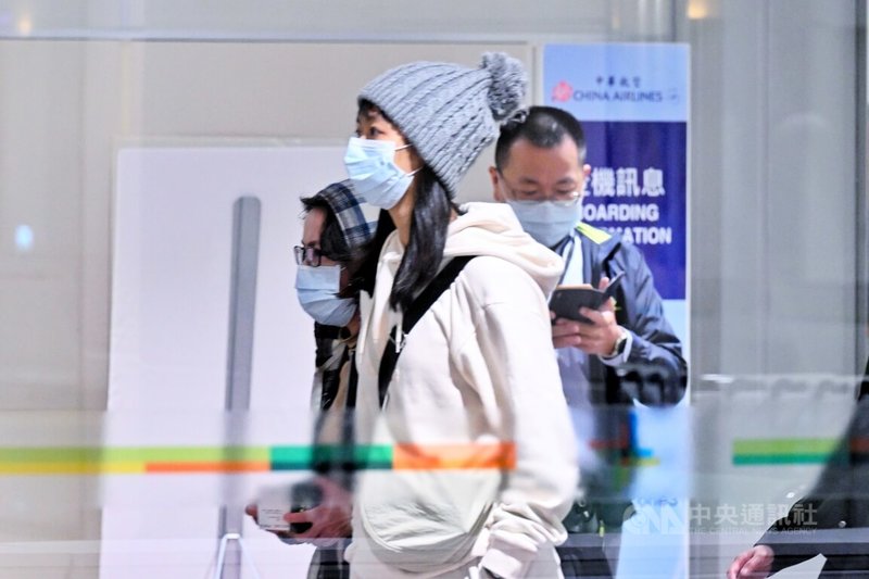 民進黨副總統參選人蕭美琴（中後）26日下午現身桃園國際機場準備啟程赴美，她穿著灰藍色格紋連帽外套、戴著口罩，全程都保持低調。中央社記者吳睿騏桃園機場攝 112年11月26日