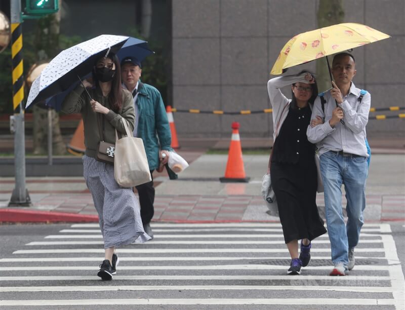 圖為台北市信義區民眾撐傘遮擋雨勢。（中央社檔案照片）