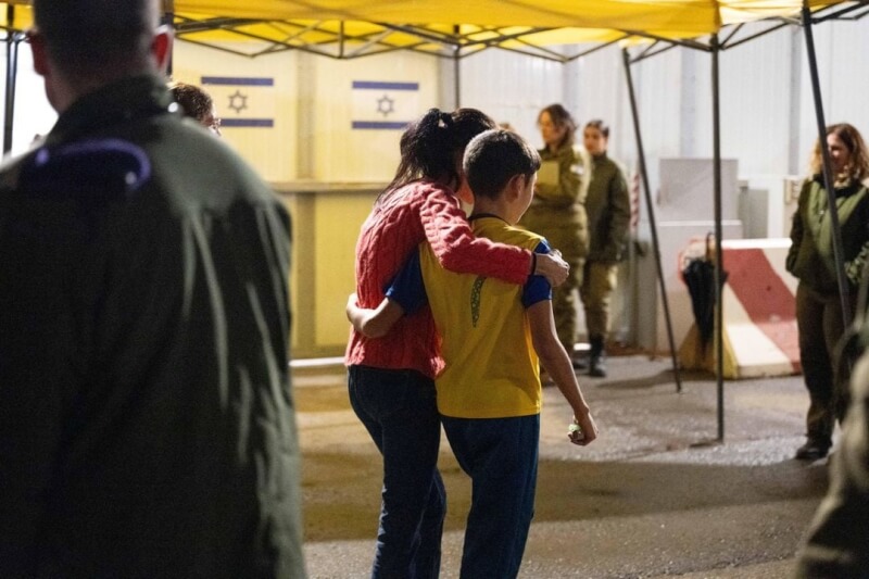 圖為一名被哈瑪斯擄走的12歲人質（右）獲釋，與他的母親在以色列南部克瑞沙洛邊境行走。（以色列國防部發言人/Handout via REUTERS）