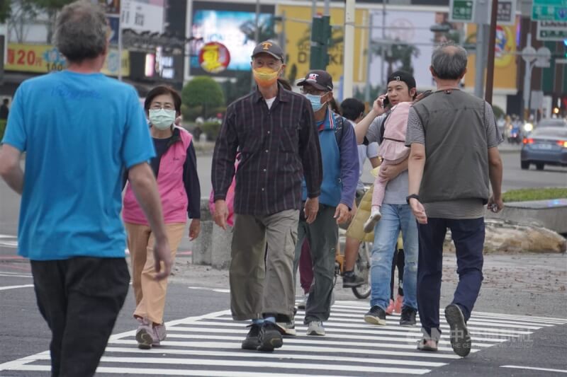 圖為27日高雄街頭外出民眾穿著長袖衣物保暖。（中央社檔案照片）