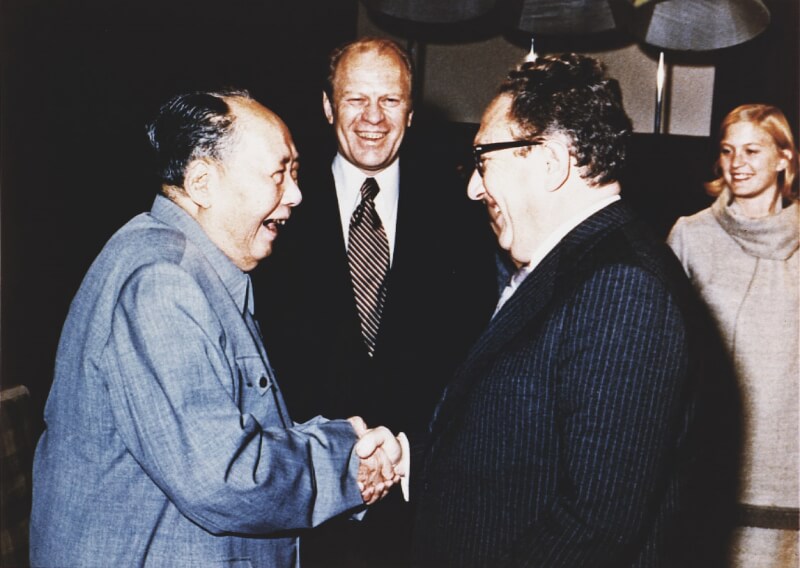 1975年12月1日，季辛吉（前右）訪問中國與毛澤東（前左）握手。（圖取自維基共享資源；版權屬公有領域）
