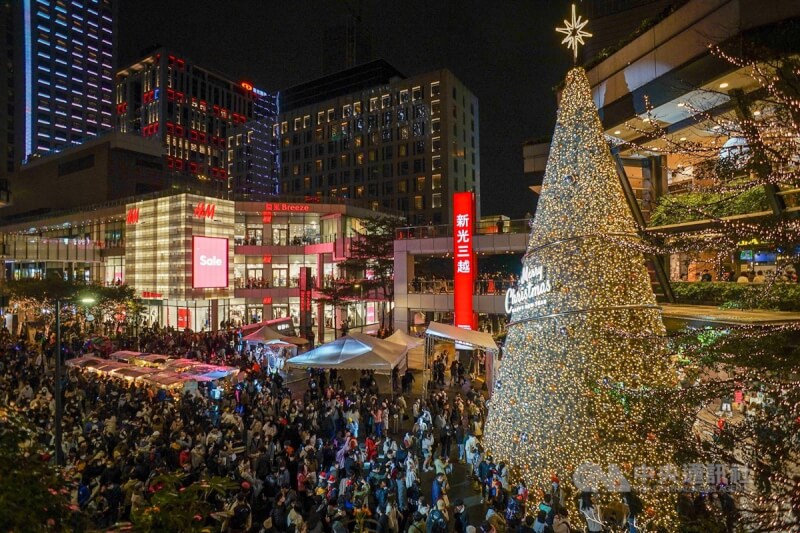 圖為2021年12月北市信義區商圈巨型耶誕樹下拍照民眾。（中央社檔案照片）