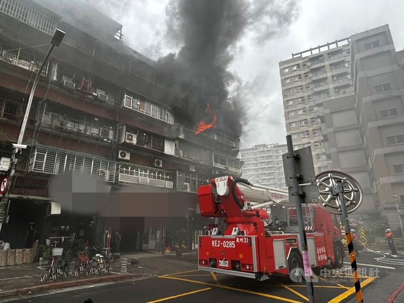 台北市警消1日上午獲報萬華區中華路2段附近巷弄內一處公寓發生火警，消防員到場時現場已冒出火舌，火勢在20分鐘內撲滅，案發原因待查。（翻攝畫面）中央社記者劉建邦傳真  112年12月1日