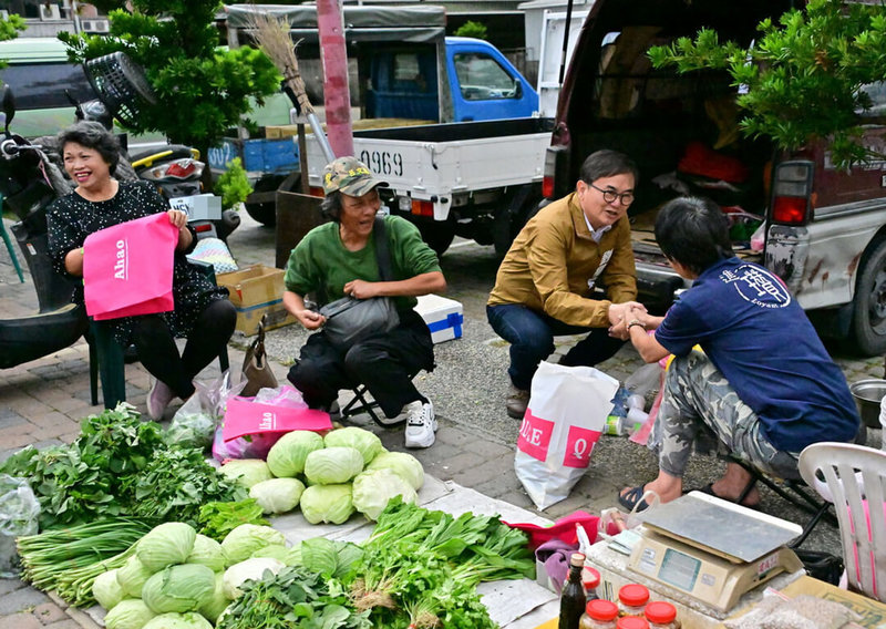 以無黨籍身分投入選舉力拚連任的立委劉櫂豪(右2)1日街頭掃街拜票,和市場攤商及採買民眾互動致意。(劉櫂豪服務處提供)中央社記者盧太城台東傳真 112年12月1日