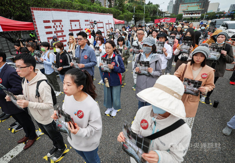 台灣動物社會研究會2日在凱達格蘭大道舉行「為母雞挺身而站」行動，在柏油路上標記出一格格紙張A4大小區塊，讓與會民眾站入體驗被飼養在格子籠的母雞處境，呼籲政府重視國際動物福利趨勢，明確制訂廢除「格子籠」期程。中央社記者裴禛攝　112年12月2日