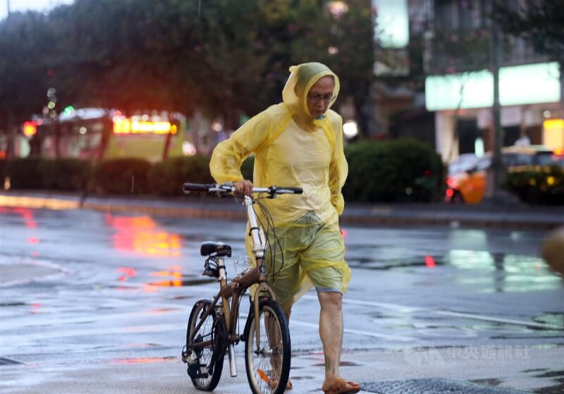 圖為民眾傍晚穿著輕便雨衣在街頭前進。（中央社檔案照片）