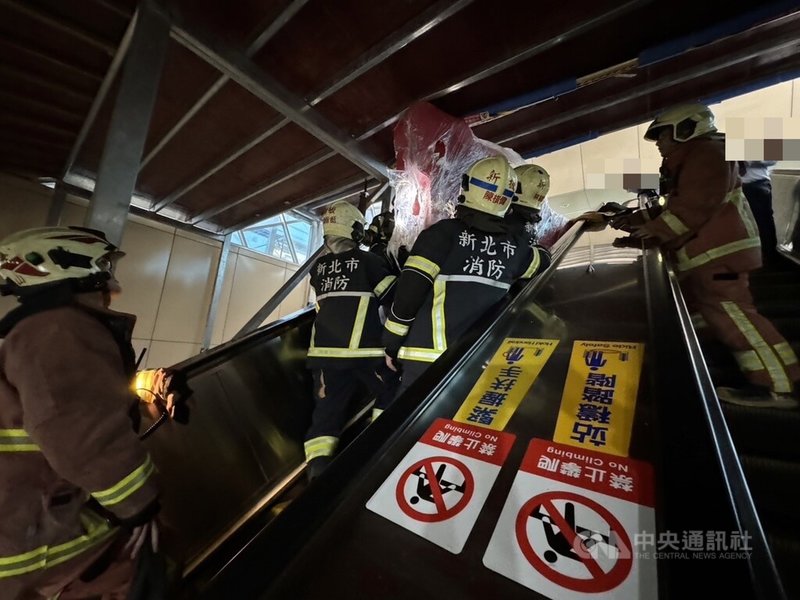 1名男子4日搬運木製造景搭手扶梯進捷運板橋站，因造景高度頂到天花板卡住而被壓傷，新北警消獲報到場協助先將造景破壞並搬開。（翻攝照片）中央社記者王鴻國傳真  112年12月4日