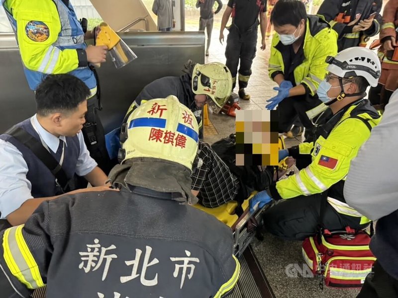 1名男子4日搬運木製造景搭手扶梯進捷運板橋站，卻因造景高度頂到天花板卡住而被壓傷，新北警消獲報到場救援並將傷者送醫。（翻攝照片）中央社記者王鴻國傳真  112年12月4日