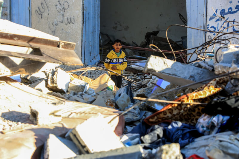 加薩走廊持續被以色列轟炸，一名孩子3日站在被摧毀的房屋之間。（安納杜魯新聞社）