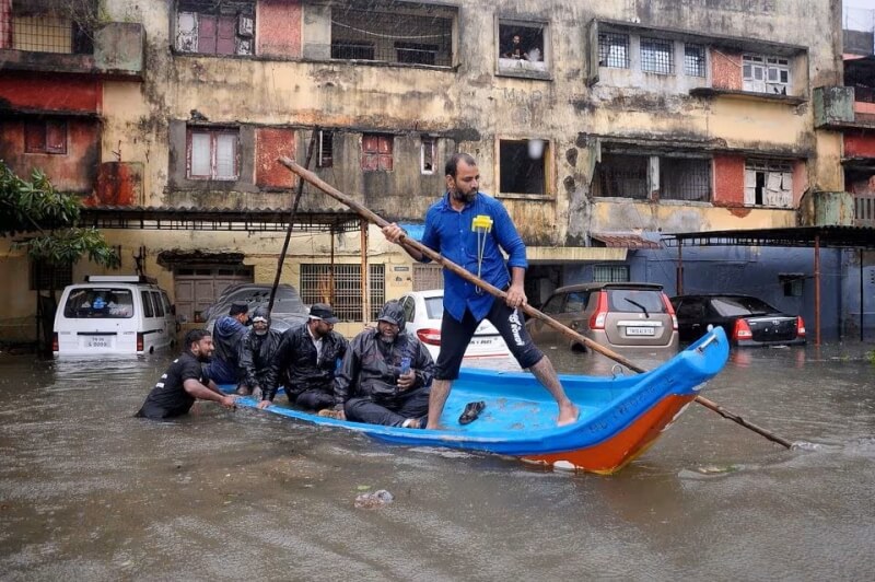 印度南部豪雨成災清奈一住宅區4日水深及腰、整排車輛泡在水裡，民眾被迫以船代步。（路透社）