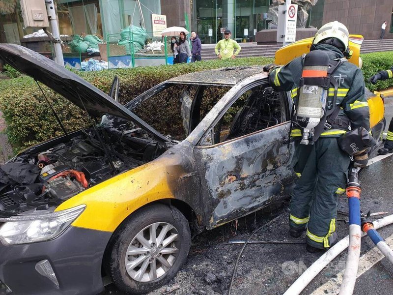 台北市松山區敦化北路一帶5日發生火燒車事件，一輛載客中的計程車不明原因起火燃燒，台北市消防局獲報立即到場滅火，肇因待查。（翻攝照片）中央社記者黃麗芸攝 112年12月5日