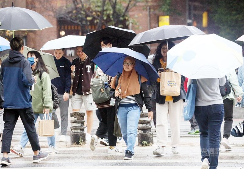 圖為台北民眾撐傘過馬路。（中央社檔案照片）