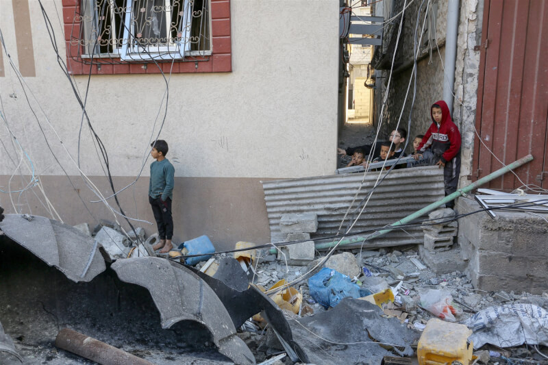 加薩孩童9日走過被以色列炸毀的房屋廢墟。（安納杜魯新聞社）