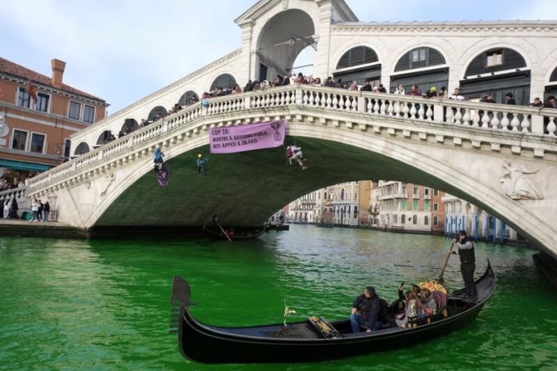 環保團體「反抗滅絕」人士9日將威尼斯大運河和義大利幾條河流染成綠色，抗議COP28缺乏進展。（路透社）