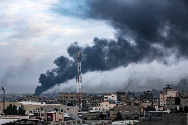 圖為加薩南部主要城市甘尤尼斯10日遭以色列襲擊，建築物冒出陣陣濃煙。（安納杜魯新聞社）