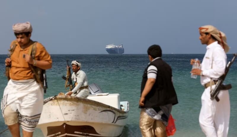 圖為武裝份子5日站在葉門一處海岸旁，遠眺之前劫持的貨輪Galaxy Leader。（路透社）