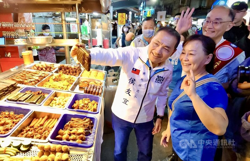 國民黨總統參選人侯友宜（前左）與黨籍立委參選人黃柏霖（2排右）13日晚間前往高雄市三民區吉林街夜市掃街拜票，並與民眾自拍留念。中央社記者董俊志攝  112年12月13日