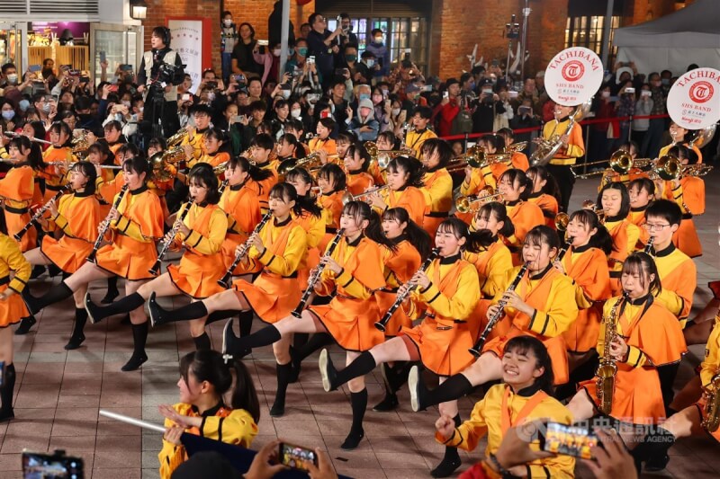 在台灣掀起「橘色旋風」的日本京都橘高校吹奏樂部12日現身台北紅樓廣場,「橘色惡魔」演奏動感曲目搭配活潑肢體動作,炒熱現場氣氛。中央社記者王騰毅攝 112年12月12日