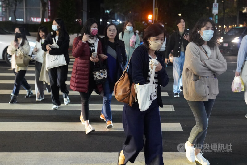 圖為台北市信義區街頭民眾穿著保暖外套過馬路。（中央社檔案照片）