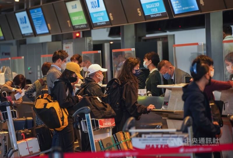 圖為台北松山機場旅客排隊辦理出境手續。（中央社檔案照片）