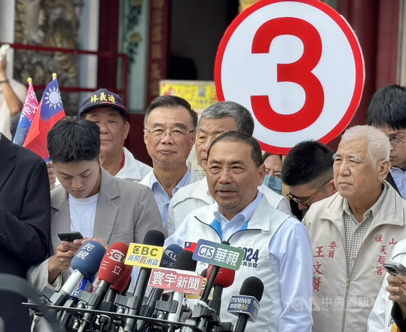 國民黨總統參選人侯友宜（前中）14日在高雄車隊掃街前接受媒體聯訪表示，若當選總統，會把青年購屋貸款免付頭期款及兒童課後照顧免費政策列為優先處理重要項目。中央社記者蔡孟妤攝  112年12月14日