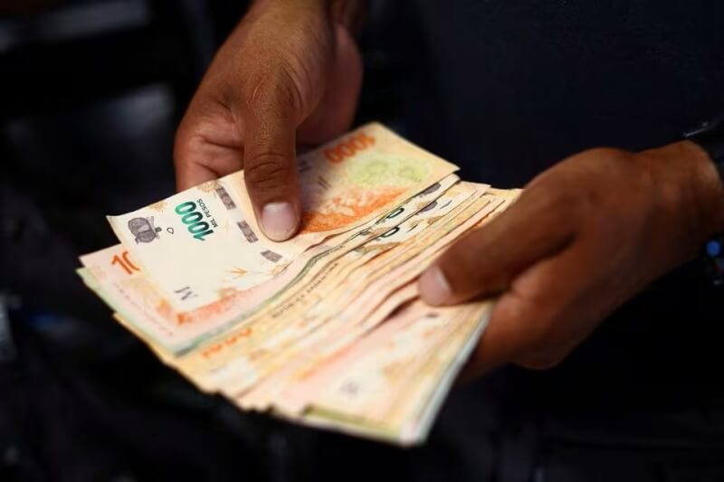 阿根廷首都布宜諾斯艾利斯街頭12日有攤販正在數鈔票。（路透社）