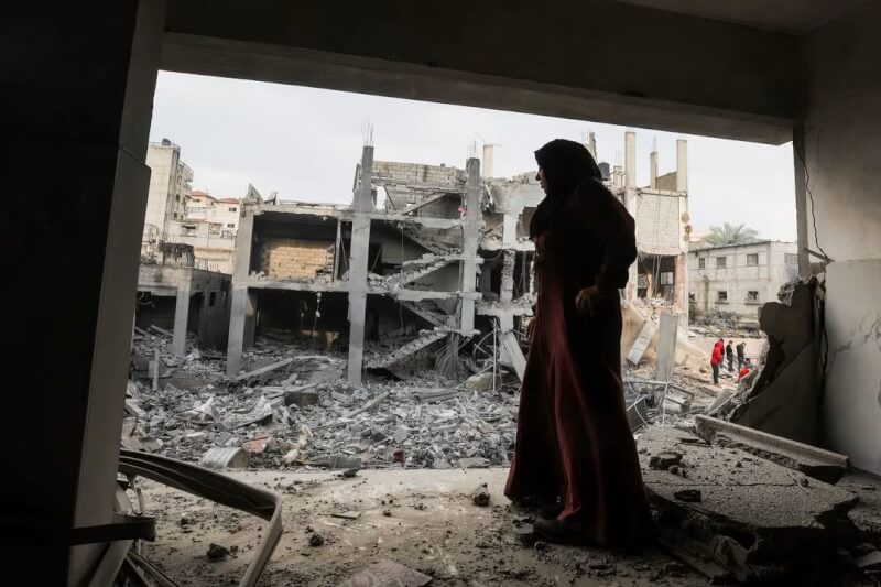 以色列襲擊加薩走廊南部，一名巴勒斯坦婦女14日站在被摧毀的房屋裡。（路透社）