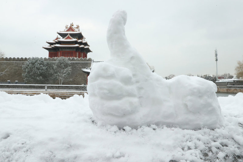 寒流持續在中國大陸發威，北京16日迎來今年最冷的一個週末，最低溫達到零下16度。圖為11日，在北京故宮角樓附近，市民用雪堆積成的「點讚」造型。（中通社提供）中央社 112年12月16日