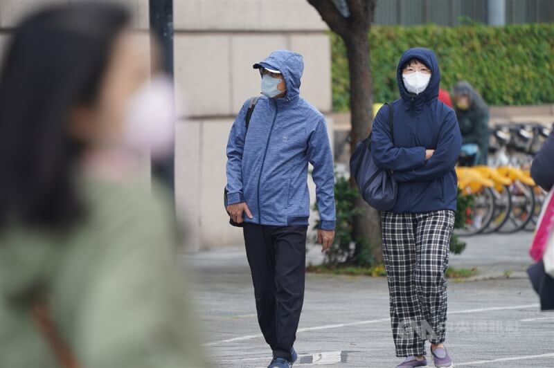 大陸冷氣團南下，中央氣象署預報愈晚愈冷，16日晚間至17日清晨低溫下探攝氏12度。台北市大同區有民眾外出外套包緊緊，做好保暖。中央社記者徐肇昌攝　112年12月16日