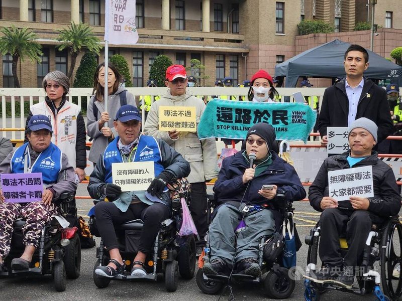 台灣障礙者權益促進會等團體17日不畏低溫，在行政院大門口舉行記者會，呼籲立專法落實無障礙環境。中央社記者陳婕翎攝  112年12月17日