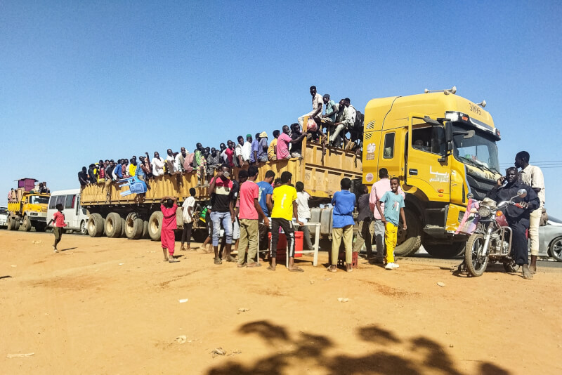 蘇丹準軍事組織「快速支援部隊」16日與政府軍交戰，成群的民眾收拾家當、步行離開瓦德馬達尼。（法新社）