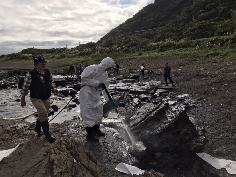 宜蘭縣環保局表示，頭城鎮大里海蝕平台附近的礁石10日起出現油污附著，縣府環保局與志工以強力水柱沖除，再以吸油棉片等吸取油漬。（宜蘭縣環保局提供）中央社記者沈如峰宜蘭縣傳真  112年12月18日