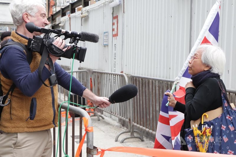 香港壹傳媒集團創辦人黎智英涉嫌違反香港國安法的案件18日開審，圖為一名示威者手持英國國旗，在法院外聲援黎智英。中央社記者張謙香港攝  112年12月18日