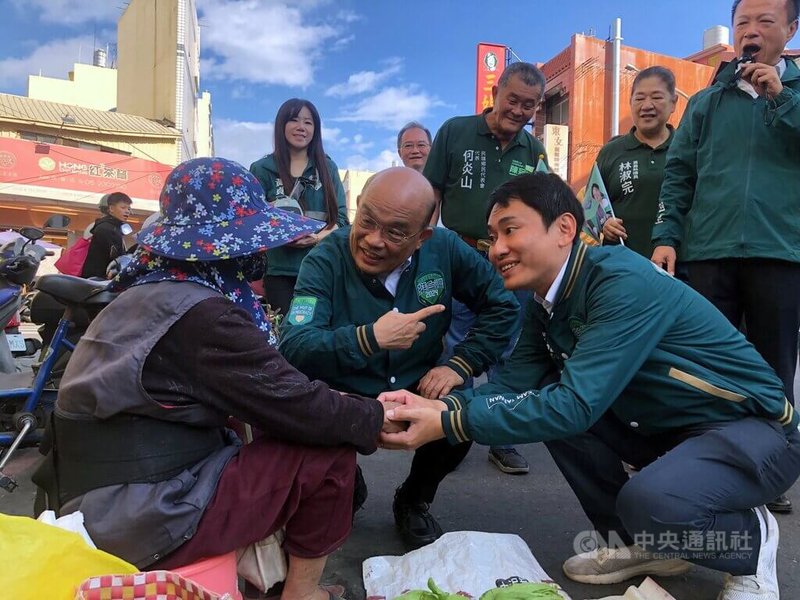 前行政院長蘇貞昌(前中)19日陪同民進黨立委參選人陳冠廷(前右)到嘉義民雄市場掃街拜票,特地蹲下來懇託鄉親支持。中央社記者黃國芳攝 112年12月19日