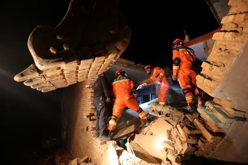 中國甘肅省積石山縣地震發生後，救難人員19日在康調村進行搜救。（中國日報via路透社）