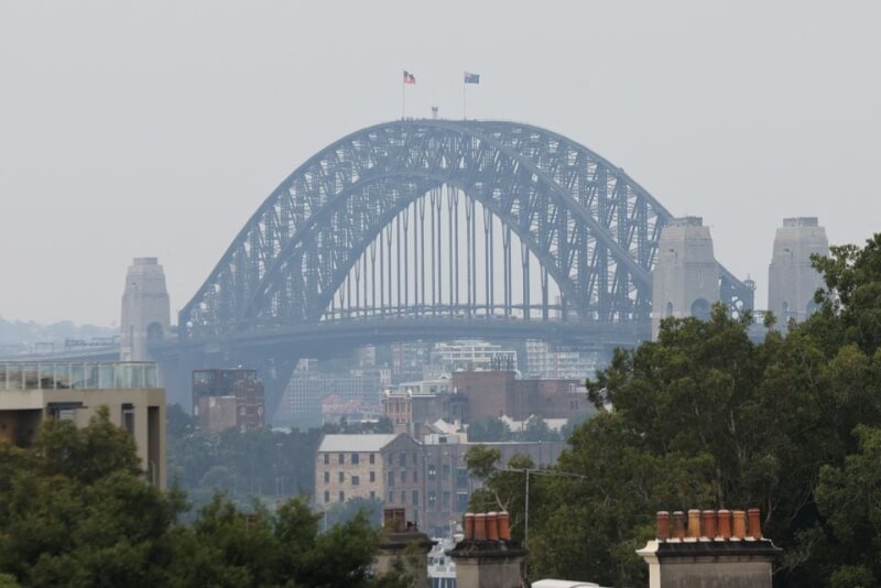 圖為19日霧霾籠罩雪梨港灣大橋。（路透社）