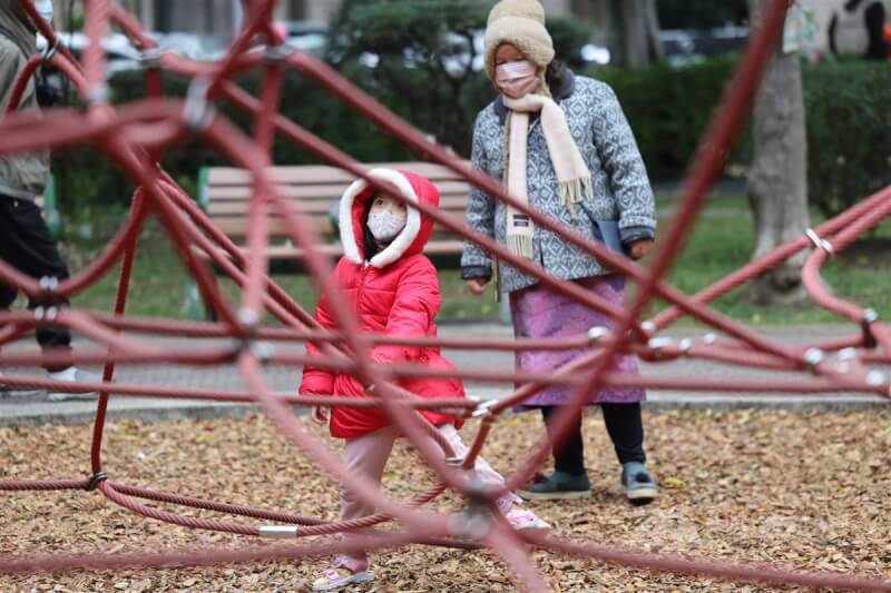 圖為民眾帶孩童到台北市中山區一處公園遊玩，穿上外套、戴帽子禦寒。（中央社檔案照片）