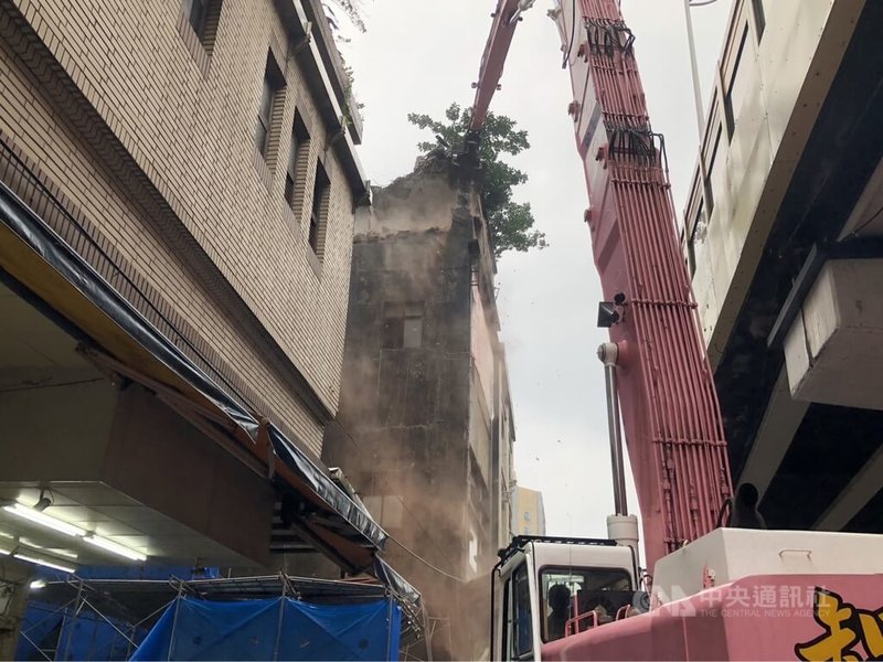 基隆市愛一路1棟4樓建物樓地板15日崩塌，壓毀騎樓多輛機車，幸無人受傷，基隆市政府21日展開強制拆除作業，怪手伸長吊臂以前端的大鋼牙破壞建物4樓，預計1個月內拆除完畢。中央社記者王朝鈺攝  112年12月21日