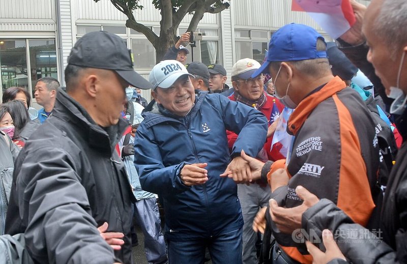 國民黨總統候選人侯友宜(中)21日到新北市鶯歌區宏德宮(孫臏廟)上香祈福,與支持群眾熱情互動。中央社記者黃旭昇新北攝 112年12月21日
