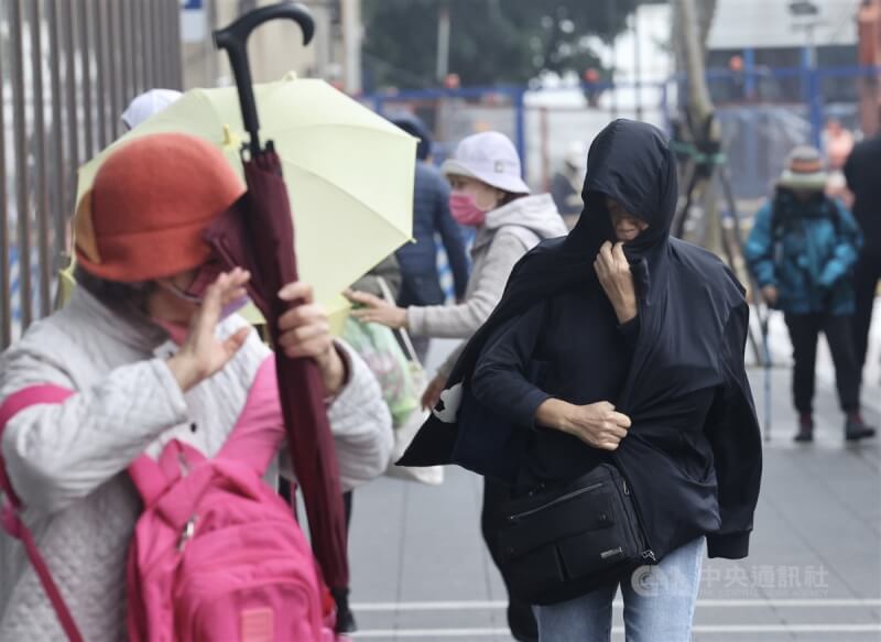北市中正區民眾21日穿著保暖衣物並攜帶雨具預防下雨。中央社記者張皓安攝　112年12月21日