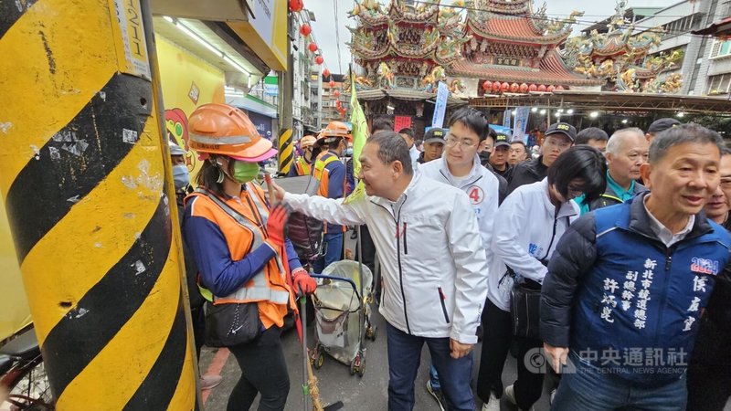 國民黨總統候選人侯友宜（左2）21日上午到新北市新莊掃街拜票，途中遇上掃街的清潔人員也不忘上前問候致意。中央社記者王鴻國攝  112年12月21日