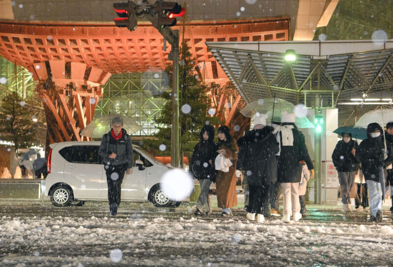 日本正受到本季入冬以來最強寒流侵襲，從北方的北海道到南方的九州地方都受影響。圖為JR金澤站前白雪紛飛。（共同社）