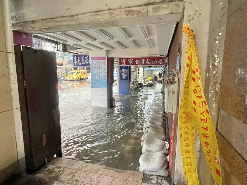 新北市板橋區南雅南路發生自來水管破裂意外,22日清晨爆管導致災情擴大,積水蔓延至道路與商家,店面前緊急堆起沙包阻擋。(民進黨籍議員黃淑君提供)中央社記者黃旭昇新北市傳真 112年12月22日