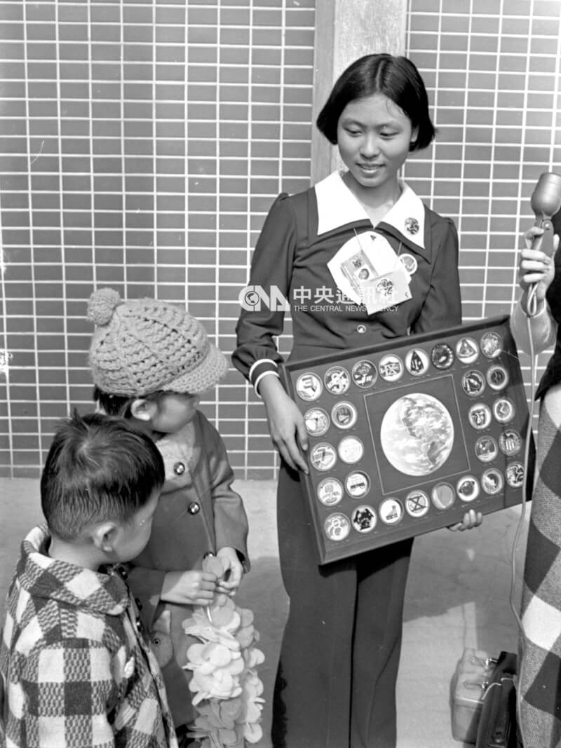 1972年12月返台的李娟瑩在機場展示歷次太陽神發射的各種紀念章，其弟妹投以羨慕的眼神。（中央上檔案照片）